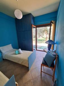 a room with a bed and a chair with a lamp at Bill's Garden Villa in Kalamos