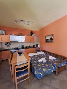 ein Zimmer mit einem Bett und einem Tisch und einer Küche in der Unterkunft Bill's Garden Villa in Kalamos