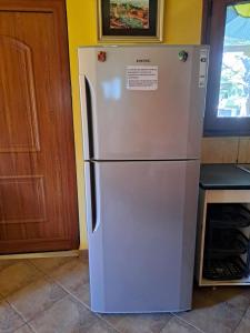 einen weißen Kühlschrank in einer Küche neben einer Tür in der Unterkunft Bill's Garden Villa in Kalamos + 47 Fotos