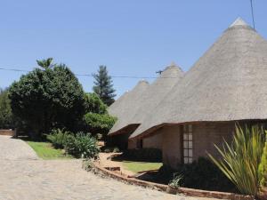 a house with a thatched roof on a beach at Bird Haven Guesthouse in Leribe