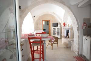 Una cocina y un comedor con mesa y sillas. en Trullo Vito with pool, en Martina Franca