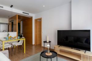 un soggiorno con una grande TV a schermo piatto di 4263 - AB Les Corts II a Barcellona