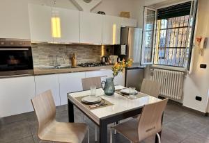 a kitchen with a table and chairs and a kitchen with white cabinets at Casa dolce casa - Metro in Sesto San Giovanni