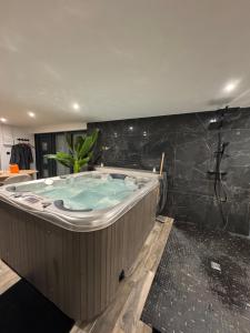 a jacuzzi tub in a room with a black wall at L'écrin in Bourges +16 photos