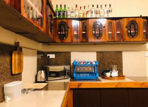 a kitchen with a counter with a microwave and some bottles at White Hill Villa in Nuwara Eliya