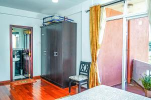 a room with a cabinet and a chair and a window at Mountain Breeze Chill Apartment in Nuwara Eliya