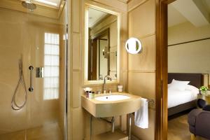 a bathroom with a sink and a shower and a bed at Hotel Balestri - WTB Hotels in Florence