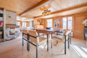 Un comedor con mesa y sillas de madera. en Panoramic 5 Bedroom Luxury Chalet with Butler, en Château-d'Oex