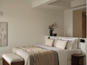 a white bedroom with a white bed with pillows at Ark in Pirgos