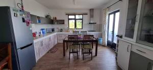 Appartement Pte aux Canonniers في بوانت أو كانونيرس: مطبخ مع طاولة مع كراسي وثلاجة