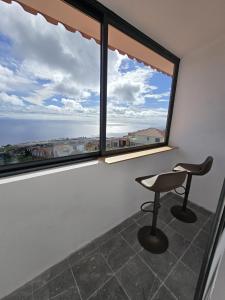 a chair in a room with a large window at AL Moniz in Machico