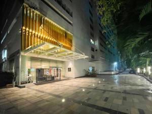 an empty street in front of a building at night at Hotel Grand regus in Bangalore