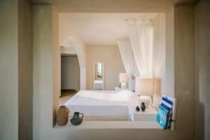 a bedroom with a white bed and a window at Village Heights Resort in Hersonissos