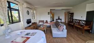 Appartement Pte aux Canonniers في بوانت أو كانونيرس: غرفة معيشة بها أريكة وطاولة +صورتان