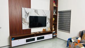 a living room with a television on a wall at Grace Villa Homestay, Cherupuzha in Peringom
