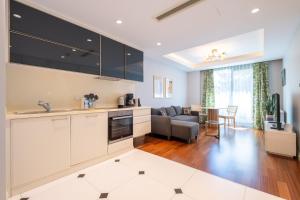a kitchen with white cabinets and a living room at Luxury Apartments in Ofton Residence in Istanbul