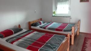 2 camas individuales en un dormitorio con ventana en Haus Wolf, en Pirmasens
