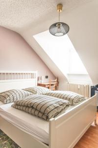 two beds in a white bedroom with a sloped ceiling at Sam & Karo Boutique Apartment in Trier