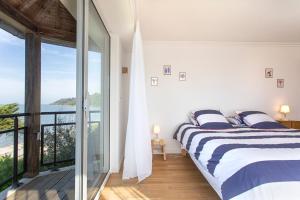 ein Schlafzimmer mit Bett und Blick auf das Meer in der Unterkunft Manava Villa vue mer et Mont Saint Michel piscine intérieure in Saint-Jean-le-Thomas + 55 Fotos