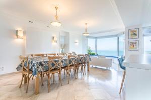 ein Esszimmer mit Tisch und Stühlen in der Unterkunft Manava Villa vue mer et Mont Saint Michel piscine intérieure in Saint-Jean-le-Thomas