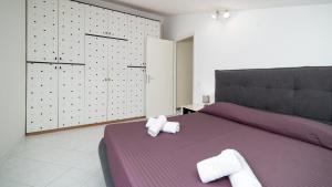 a bedroom with a purple bed with towels on it at La Mansarda di Via Montegrappa by Rentbeat in Civitavecchia