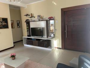 a living room with a television and a door at Casa Itacimirim in Camacari