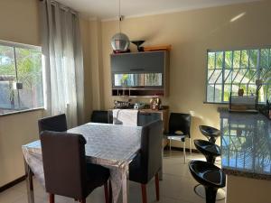 a dining room with a table and chairs and a kitchen at Casa Itacimirim in Camacari