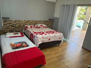 a bedroom with two beds with red and white sheets at Casa Itacimirim in Camacari +21 photos