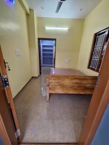 an empty room with a wooden bench in a room at Subramanya Inn in Tiruchchendūr +2 photos