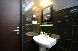 un baño con lavabo y espejo en saltlake inn, en kolkata
