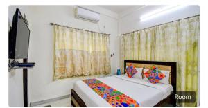 Un dormitorio con una cama y un televisor de pantalla plana. en saltlake inn, en kolkata