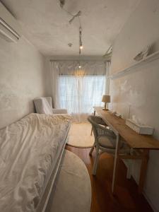 a bedroom with a bed and a desk and a window at minimalist経堂の小さなお部屋 in Tokyo