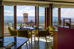 a restaurant with tables and chairs and a view of a tower at Hotel Fontebella in Assisi