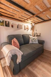 a living room with a gray couch and wooden ceilings at Sam and Karo City Studio in Trier