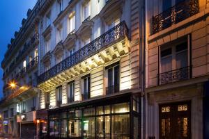 un bâtiment avec des lumières sur le côté dans l'établissement Le Relais du Marais, à Paris