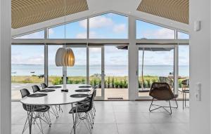 RøndeにあるNice Home In Rønde With House Sea Viewのテーブルと椅子と海のあるダイニングルーム