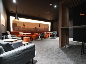 un vestíbulo con sofás y mesas y una sala de espera en JustStay Solingen Hotel & Apartments, en Solingen