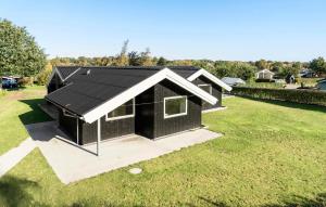una casa nera con un tetto nero su un campo erboso di 5 Bedroom Cozy Home In Hejls a Hejls Altre 14 foto