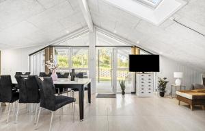 una sala da pranzo con tavolo, sedie e TV di 5 Bedroom Cozy Home In Hejls a Hejls