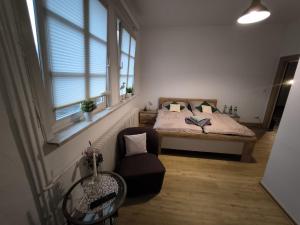 a bedroom with a bed and a chair and a window at Hotel am Klosterbrunnen in Itzehoe