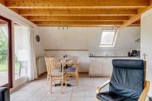 a kitchen and dining room with a table and chairs at Roerdomp I Vrijstaande Bungalow met Buiten Zitjes in Zwiggelte +49 photos