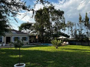 ハラレにあるStunning 2 bed with pool - 2275の木々とプールのある庭のある家