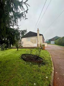 a house on the side of a street with a circle in the grass at Gite - La Boutardière in Rilly-sur-Loire