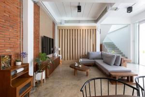 un salon avec un canapé et un mur de briques dans l'établissement White Pool Villa Chiangmai, à Chiang Mai