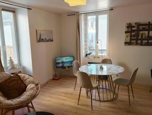 a living room with a table and chairs and a television at L 'Échappée Marine au coeur de Concarneau in Concarneau