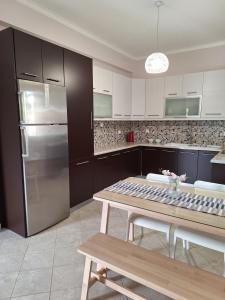 a kitchen with a table and a stainless steel refrigerator at B&B one in Vonitsa