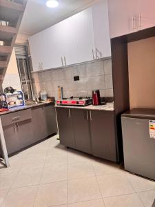 a kitchen with white cabinets and a counter top at Fatisa private homes in Kampala