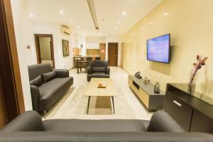 a living room with two couches and a tv at Accra Luxury Apartments at Avant Garde in Accra