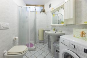 un bagno con un water, un lavandino e una lavatrice di Casa Anna a Pomonte - Goelba a Pomonte