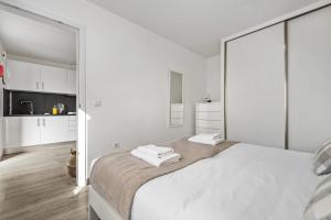 a white bedroom with white walls and a large bed at Seaside Charm II in Câmara de Lobos